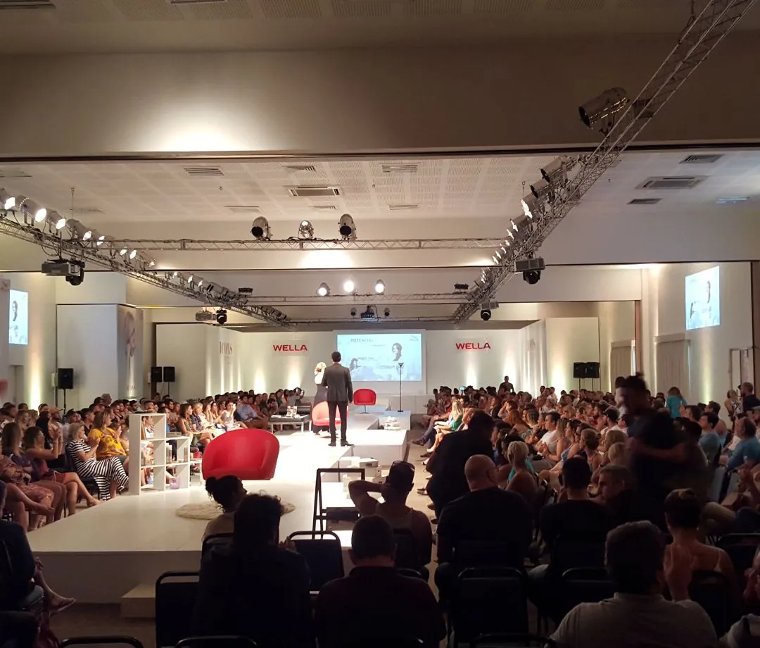 Plateia em evento com passarela e treliças de iluminação