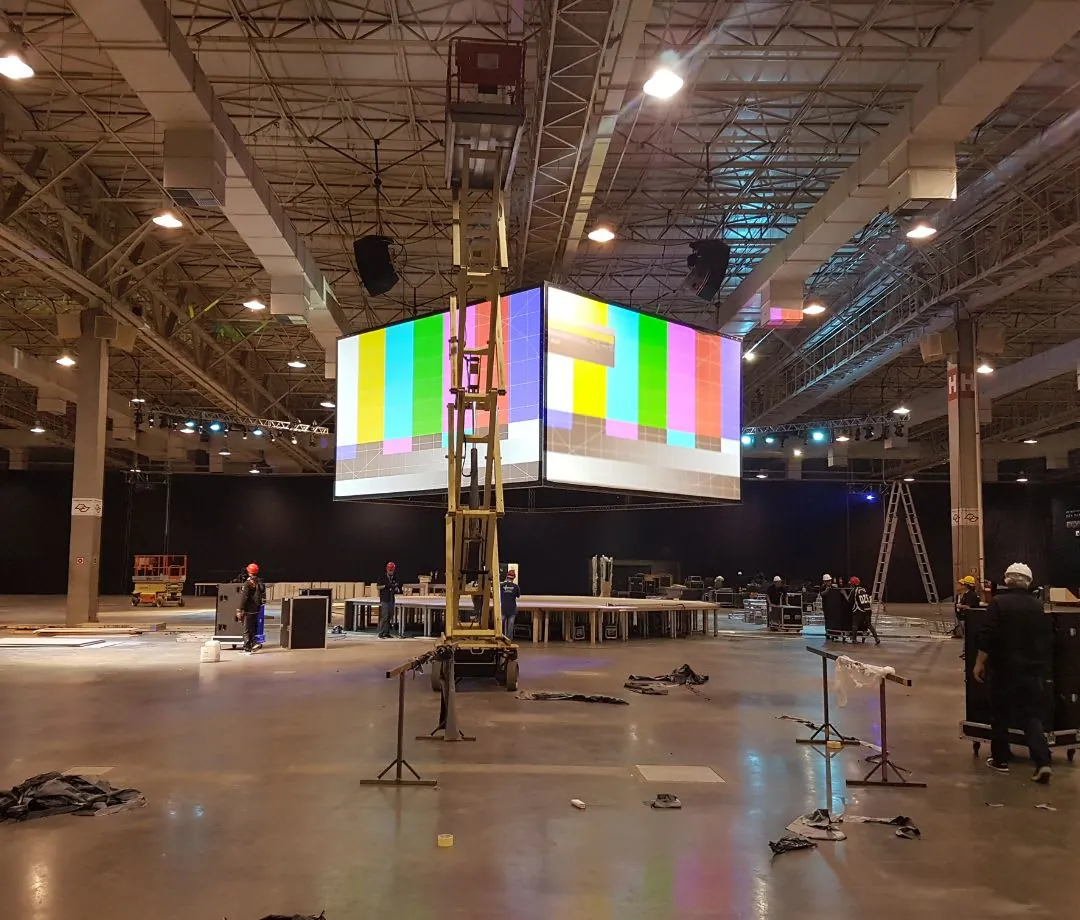 Cubo de LED suspenso em pavilhão durante a montagem