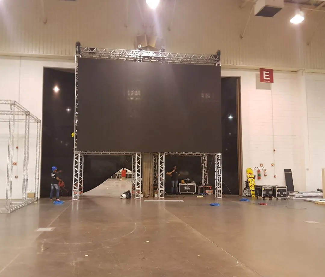 Painel de LED erguido em estrutura de treliça durante a montagem em pavilhão